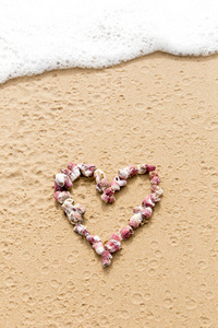 心的形状，在海滩上的粉红色海贝壳