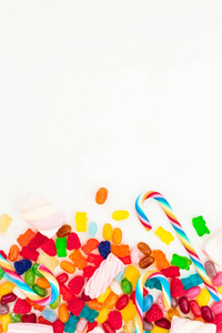 明亮的糖果和糖手杖在白色背景。平躺, 顶部视图