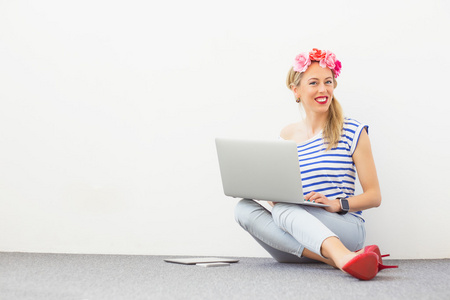 时尚博客作者坐在地板上，使用计算机