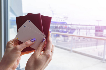 特写美丽的女子手拿护照和登机牌在机场候机楼。旅行和假日概念。候机大厅。空的空间。复制空间