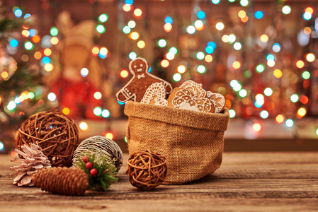 新年或圣诞节作文与姜饼和圣诞节香料在帆布袋子与冷杉分支和锥体在老木桌, 选择的焦点