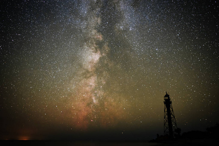 旧灯塔的剪影沙滩和海洋对星空的背景