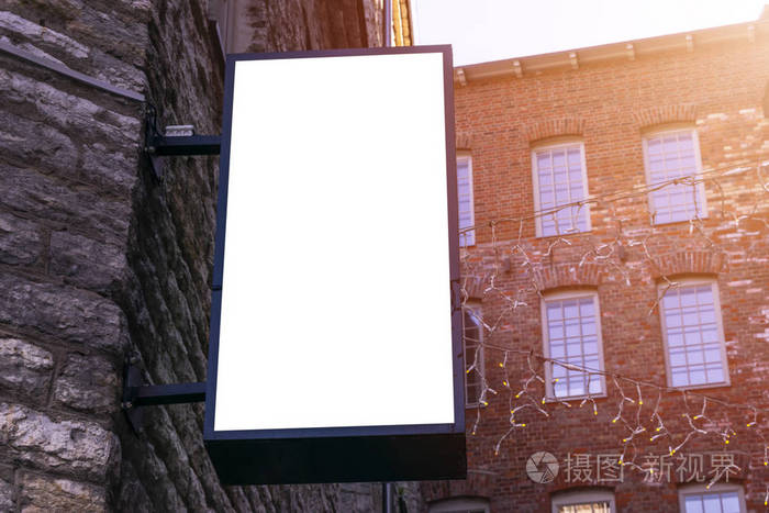 城市街道上空白的白色广告牌.在背景街道和岩石.模仿.在街上的海报.