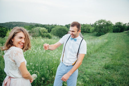 幸福的新娘和新郎在绿色草地上行走