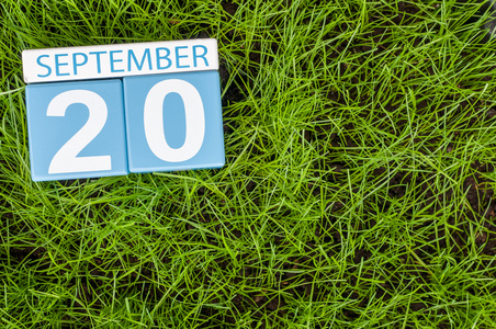 9 月 20 日。9 月 20 日的形象上绿草草坪背景的木制彩色日历。秋季的一天。文本为空的空间