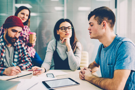 年轻英俊的时髦的家伙解释作业任务 teamworking 与大学的朋友在校园, 千年男女学生分析和讨论 coworking sp