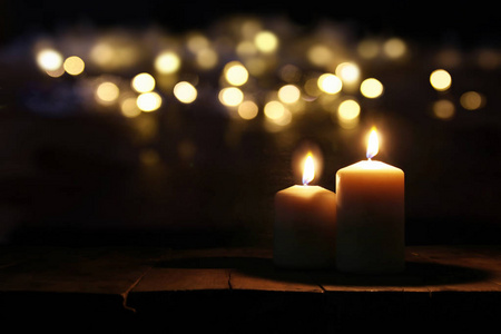 燃烧的蜡烛，在旧的木桌上散景灯