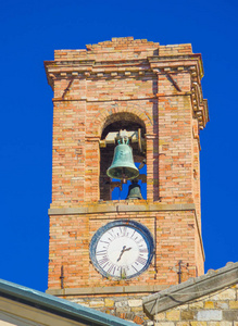 塔与石头和砖砌体响铃标记时间在中世纪起源的古村落在蓝天