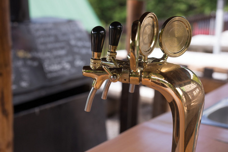 金色酒吧在酒吧的金色啤酒水龙头照片