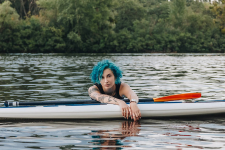 有魅力的年轻女子, 蓝色的头发放松在水上板