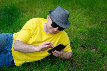 在手机上的草黄色 t 恤的男人
