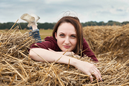 在田野里玩的年轻女孩, 躺在干草堆上