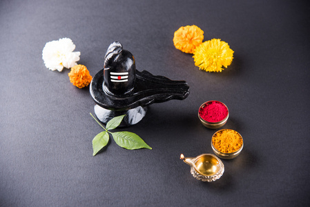 湿婆 Linga 组成的黑色石头装饰着鲜花与桔叶称为 Aegle marmelos，在黑色的背景，摩诃湿婆 ratri 节的印度