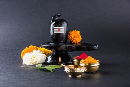 湿婆 Linga 组成的黑色石头装饰着鲜花与桔叶称为 Aegle marmelos，在黑色的背景，摩诃湿婆 ratri 节的印度