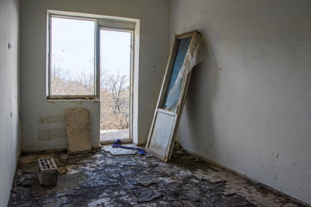 在废弃的房子里的启示录内部, 空房间和破碎的窗口与自然景观和山脉的背景。破坏和战争概念