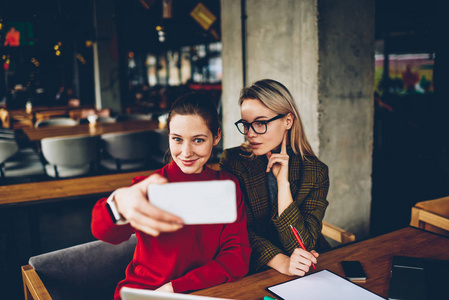 迷人的年轻女子和开朗的同事在 coworking 的合作期间, 在数码智能