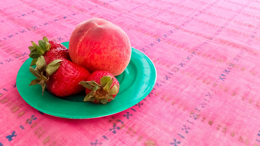 盘子里的草莓和桃子