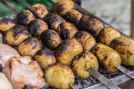 烤土豆腌在草药和香料。在烧烤食品上做饭。烤土豆特写
