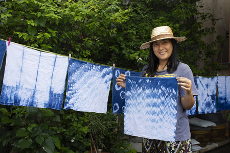 泰国妇女领带蜡染染色手帕领带蜡染靛蓝色或 mauhom 颜色和挂起工艺干燥衣服在阳光下的花园户外在暖武里, 泰国