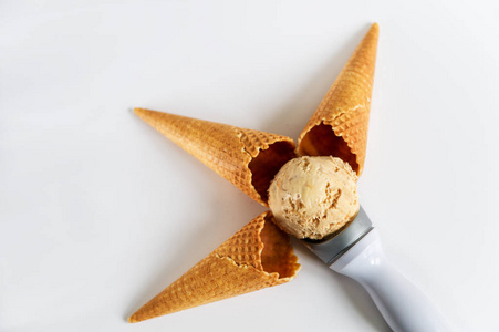 褐色锥形华夫饼短号用焦糖球冰淇淋在白盘子上