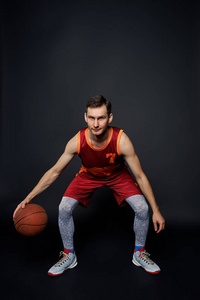 一个篮球运动员的全长肖像与黑色工作室背景球