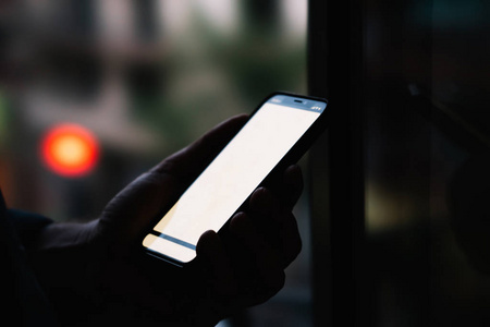 设备持有侧面关闭视图的男性持有现代智能手机与模拟复制空间屏幕, 而