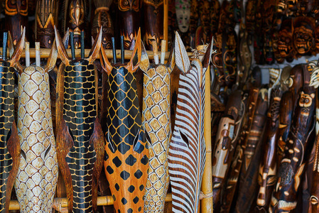 雕刻的木长颈鹿面具显示出售在一个工艺市场。关闭一般非洲雕刻的长颈鹿。多彩的纪念品背景。纪念品商店卖纪念品和工艺品