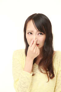 日本女人抱着她的鼻子因为难闻的气味