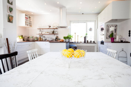 新鲜柠檬在玻璃碗在晚餐桌与厨房在背景上