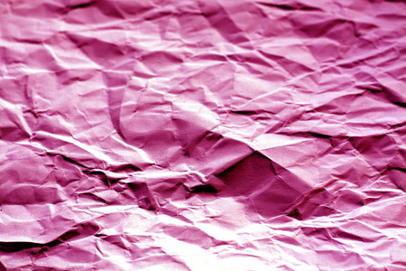 在粉红色色调的模糊效果的皱巴巴的纸页。设计的抽象背景和纹理