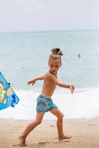 小男孩在海滩上用奔跑