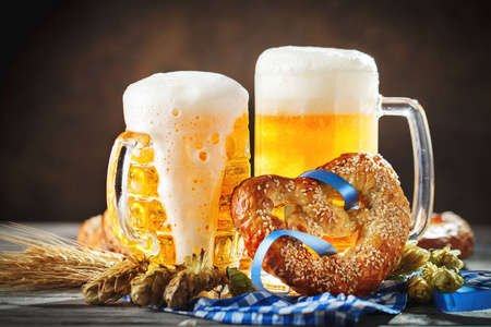 啤酒杯和椒盐脆饼放在木桌上。慕尼黑。啤酒节