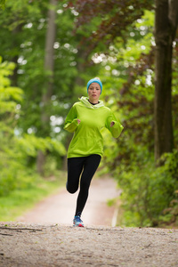 运动年轻的女性跑步者在森林里