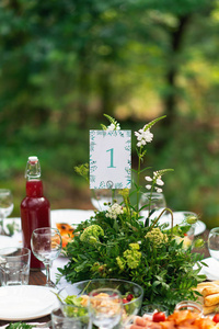典雅的婚庆餐桌布置, 花卉装饰, 餐厅。婚礼桌的设置。婚礼在森林里