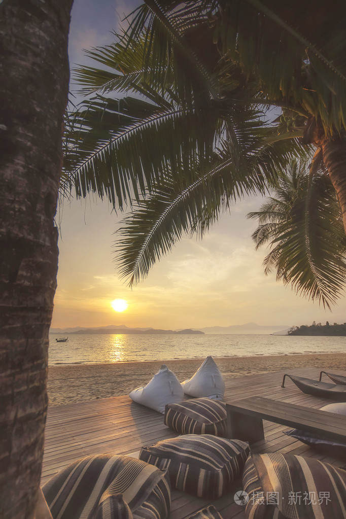日出与垫子和椰子棕榈树的意见在泰国拉廊省攀沿岛的热带海滩背景