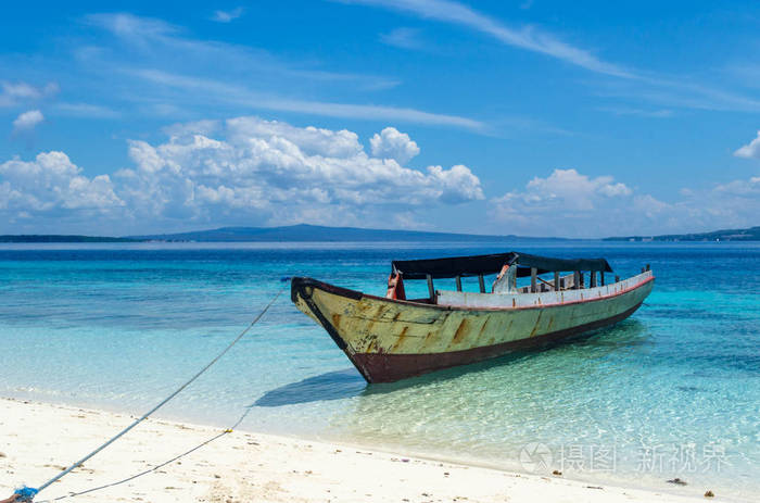 一只孤独的小船住在海边, 四周是海龟清澈的海水.天空在白云中.没有人