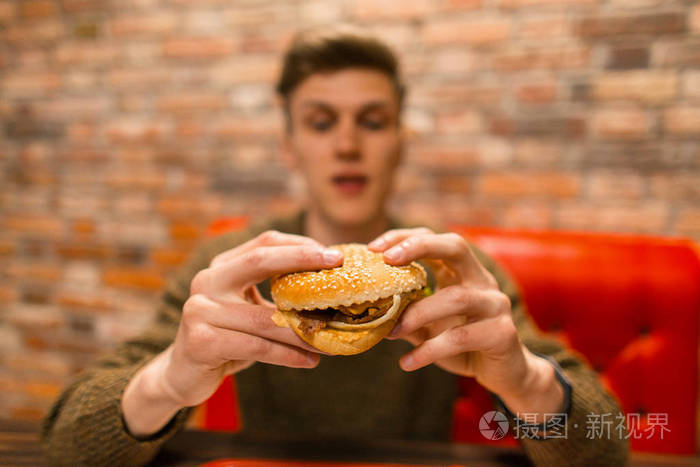 时髦的人在咖啡馆吃美味的汉堡包