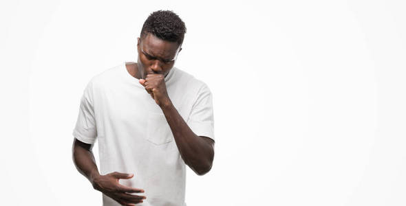 年轻的非洲裔美国人穿白色 t恤感觉不适和咳嗽作为症状为感冒或支气管炎。医疗保健理念