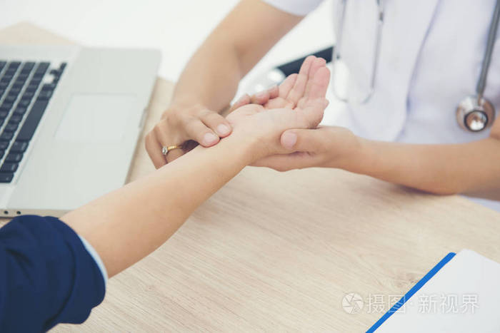 护士检查病人的脉搏手在医院的桌子上