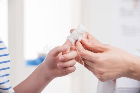 受伤的包扎的手指上白色孤立手指受伤用绷带包扎受伤的包扎的手指