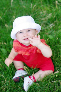 夏天，可爱的婴儿坐在草地上抬头看