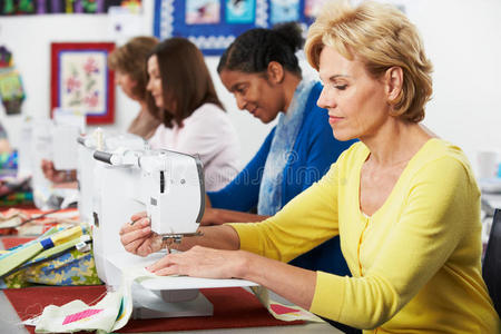 在课堂上使用电动缝纫机的一群妇女