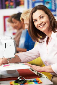 在课堂上使用电动缝纫机的一群妇女