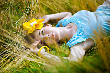 年轻性感的女人在户外的草地上放松