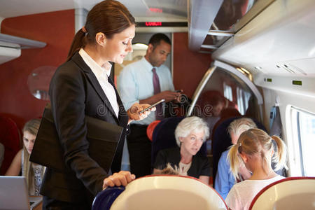在繁忙的通勤列车上使用手机的女商人