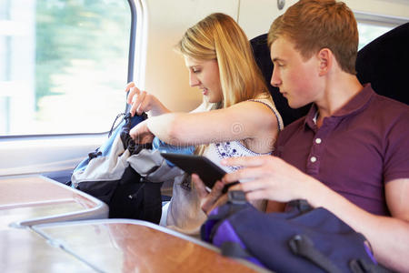 一对年轻夫妇在火车旅行中读电子书