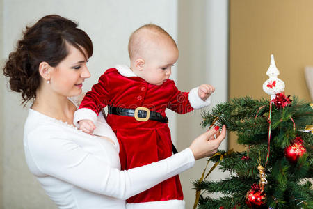 母亲和女婴装饰圣诞树