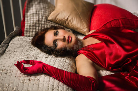 躺在床上穿着红色连衣裙的性感黑发女郎