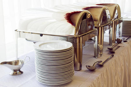 餐桌上的金属厨房设备和盘子，用于精致的婚宴或其他盛宴