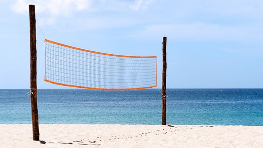 在沙滩排球网。排球网上海滩，蓝色的大海，清晰和晴朗的天空